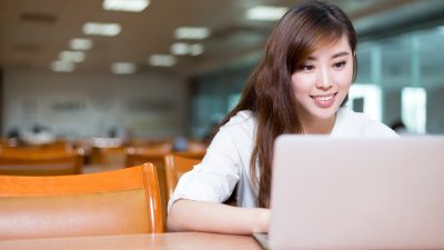 Asian beautiful female student study in library with laptop Asian beautiful female student study in library with laptop